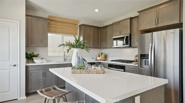 a kitchen with a refrigerator a stove a sink and a kitchen island