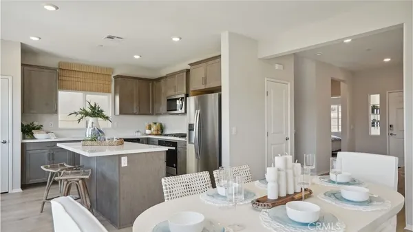 a kitchen with stainless steel appliances kitchen island granite countertop a kitchen island a stove a table and chairs