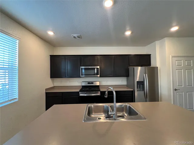 a kitchen with a refrigerator and a sink
