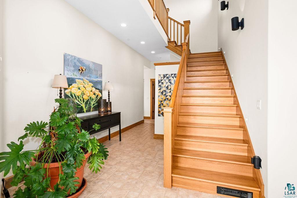 4856 Kingston Street Duluth, MN 55804 - Photo 21 of 88 Bright entryway featuring a hardwood staircase with matching banister and railing, recessed lighting, and tile flooring