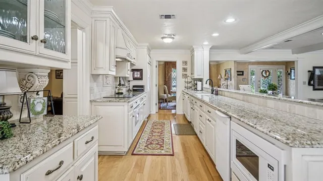 a large kitchen with granite countertop lots of counter space and stainless steel appliances