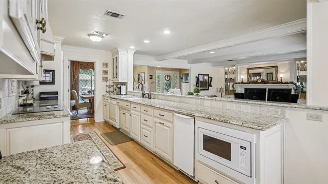 a large kitchen with stainless steel appliances granite countertop a stove and a sink