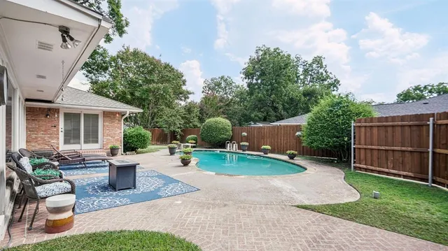a view of a backyard with sitting area and garden