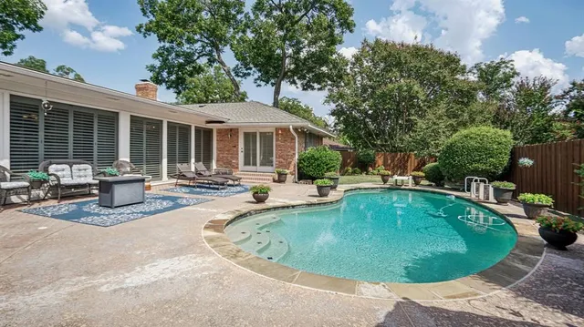 a view of a house with swimming pool and sitting area