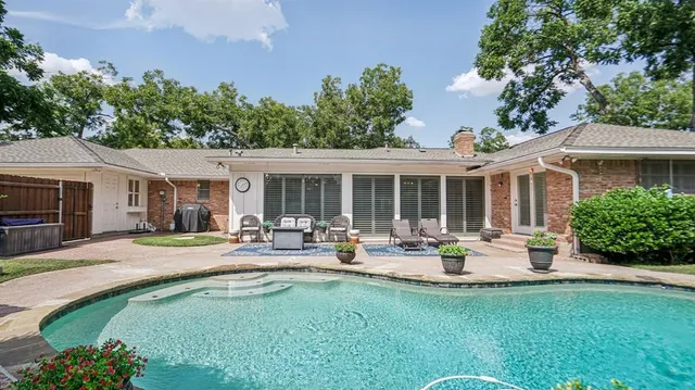 a house view with swimming pool and garden space