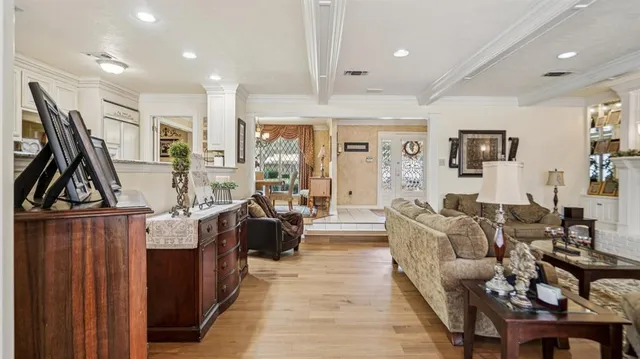 a living room with furniture a large window and wooden floor