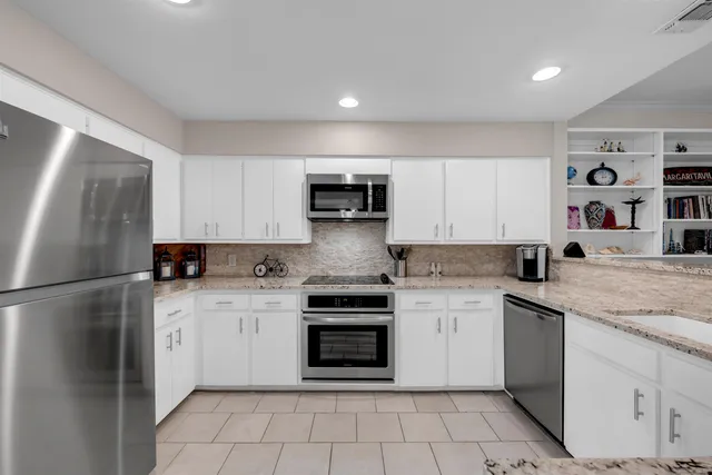 a kitchen with stainless steel appliances granite countertop a refrigerator sink and stove
