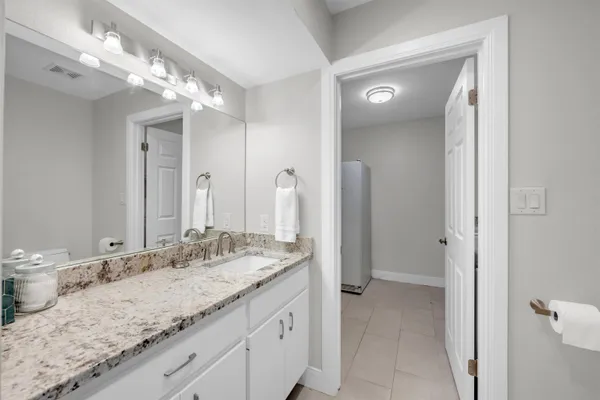 a bathroom with a granite countertop sink a large mirror and a shower