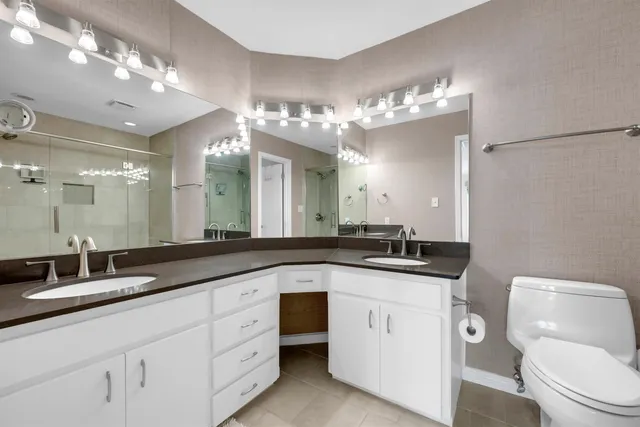 a bathroom with a granite countertop sink a toilet and a mirror