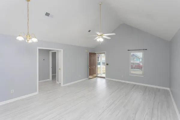 wooden floor in an empty room with a kitchen