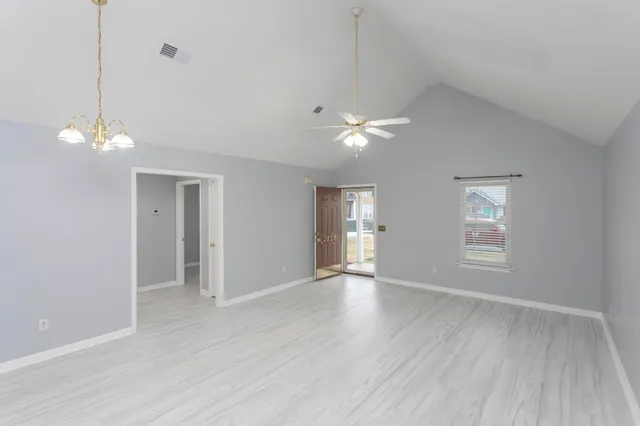 wooden floor in an empty room with a kitchen