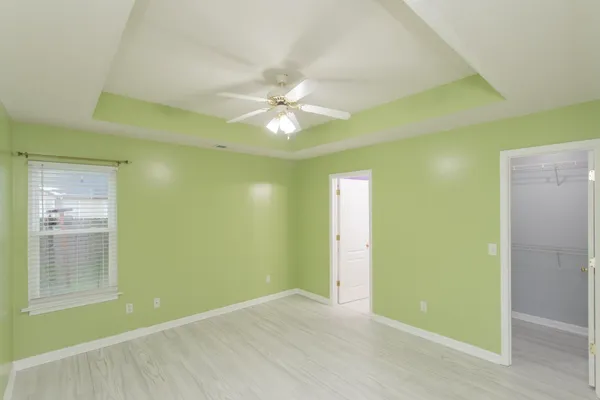 a view of an empty room with window and a ceiling fan