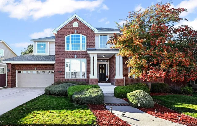 a front view of a house with a yard and potted plants
