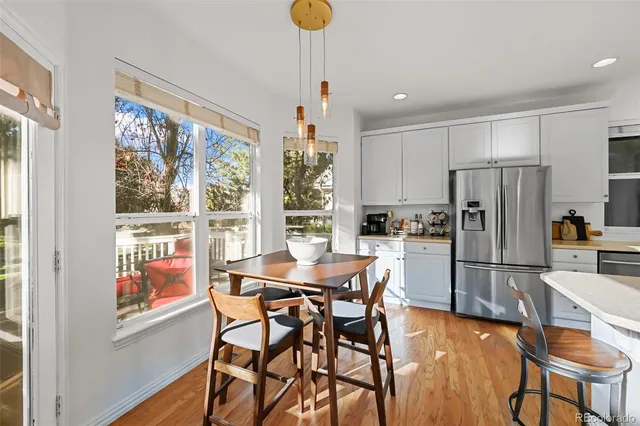 a kitchen with stainless steel appliances a dining table chairs and chandelier