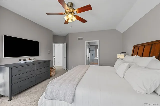 a bedroom with a large bed and a flat screen tv