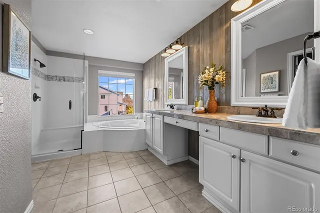 a large white bathroom with a double vanity sink a mirror and a bathtub