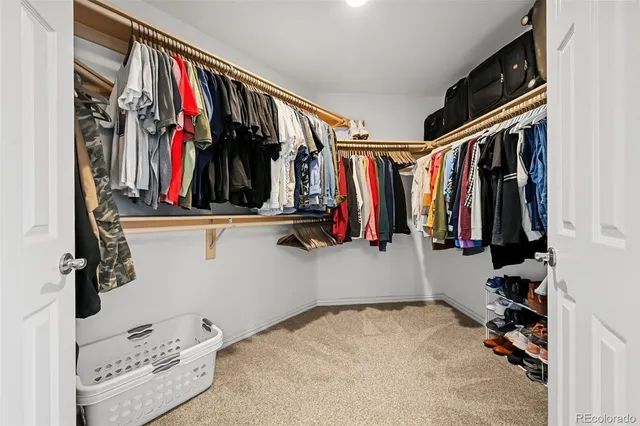 a view of walk in closet with clothes and shoes