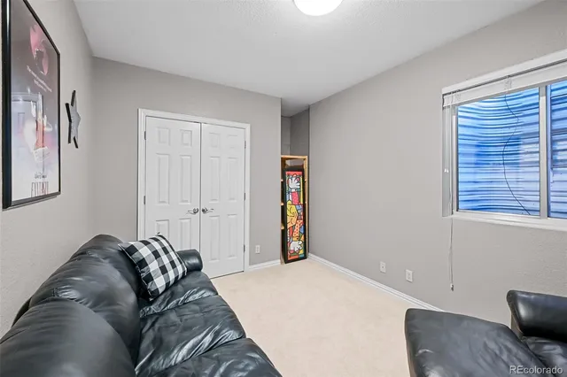 a bed sitting in a bedroom next to a window and a chair