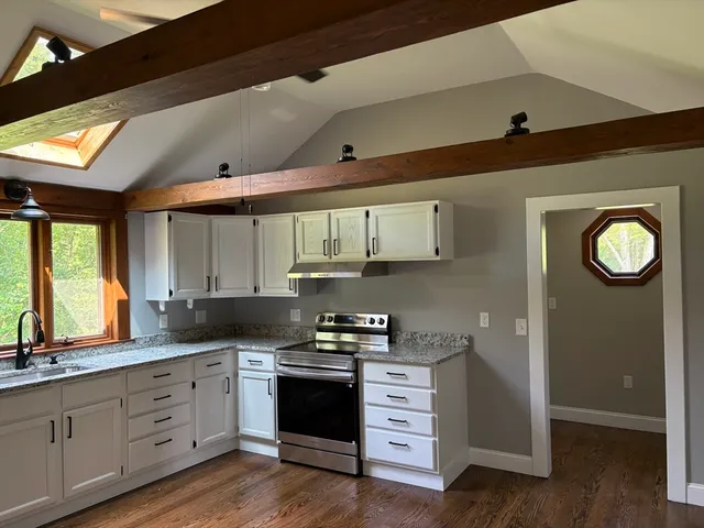 a kitchen with granite countertop a refrigerator stove and sink