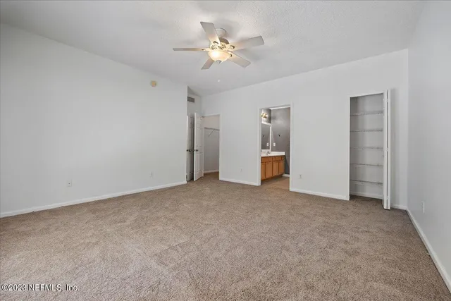 a view of an empty room with a ceiling fan