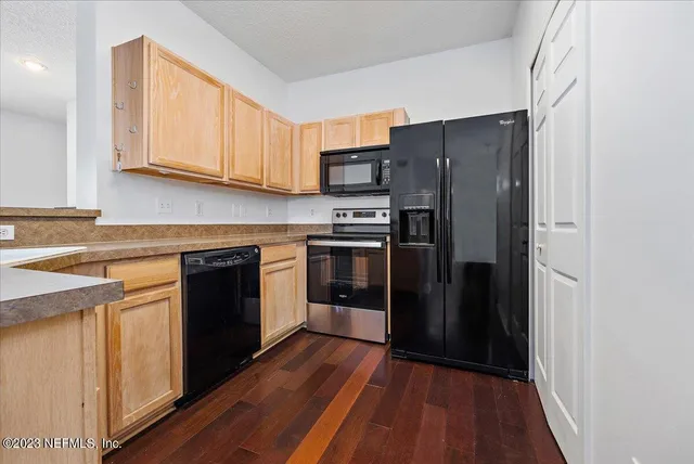 a kitchen with stainless steel appliances granite countertop a refrigerator and a stove top oven