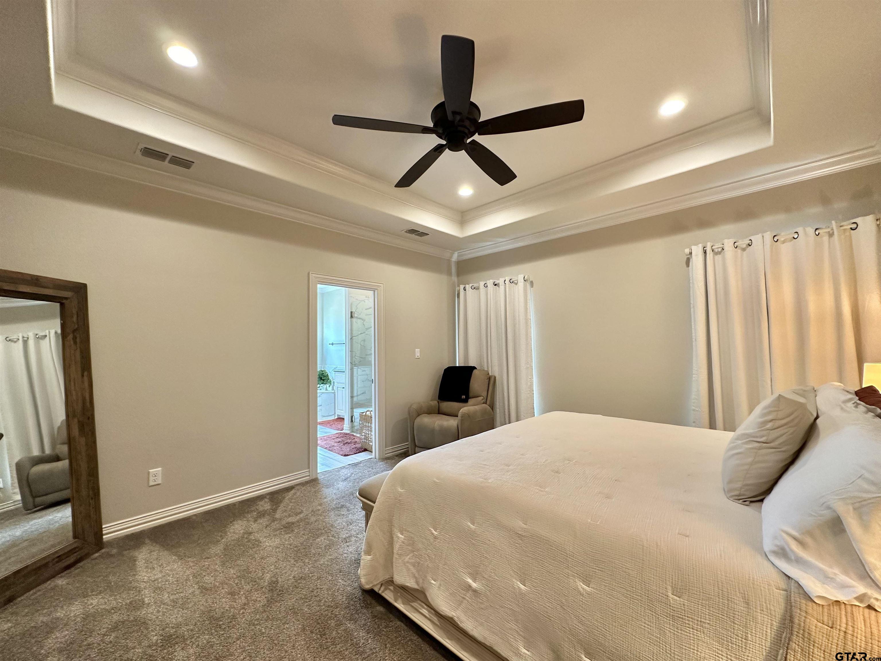 345 Willow Creek Ranch Road Gladewater, TX 75647 - Photo 27 of 47 a bedroom with a large bed and a ceiling fan