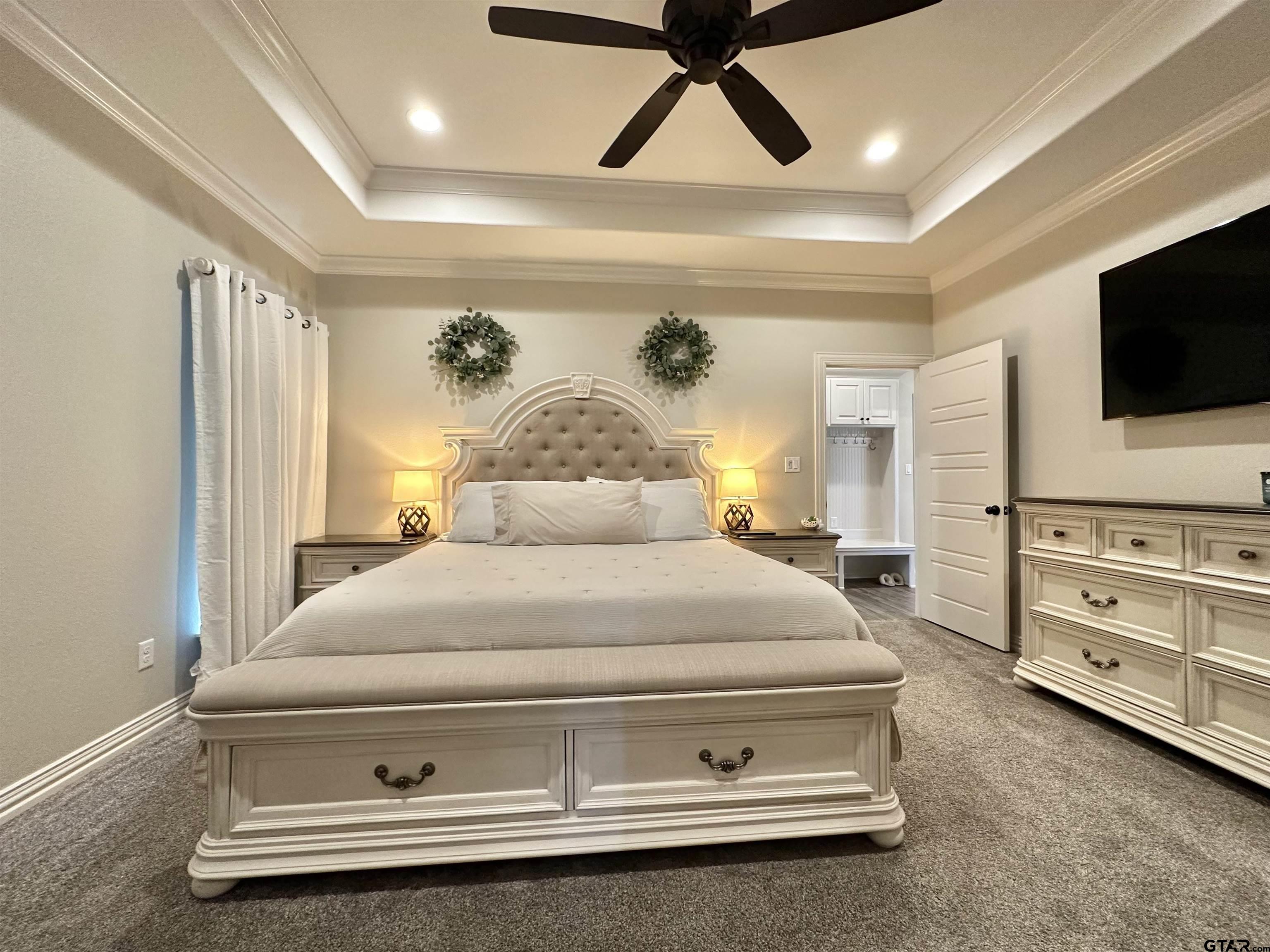 345 Willow Creek Ranch Road Gladewater, TX 75647 - Photo 28 of 47 a spacious bedroom with a bed and flat screen tv