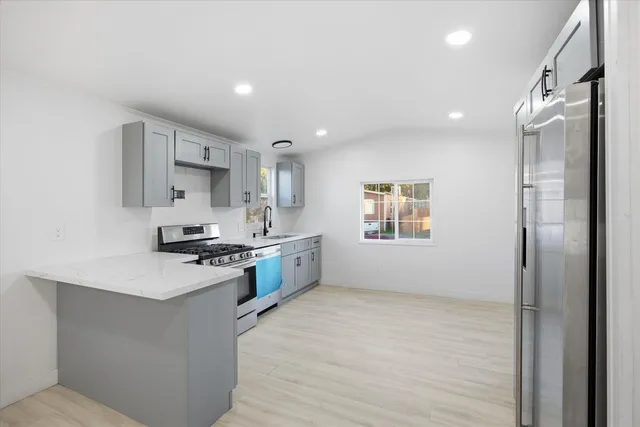 a kitchen with stainless steel appliances a refrigerator sink and stove