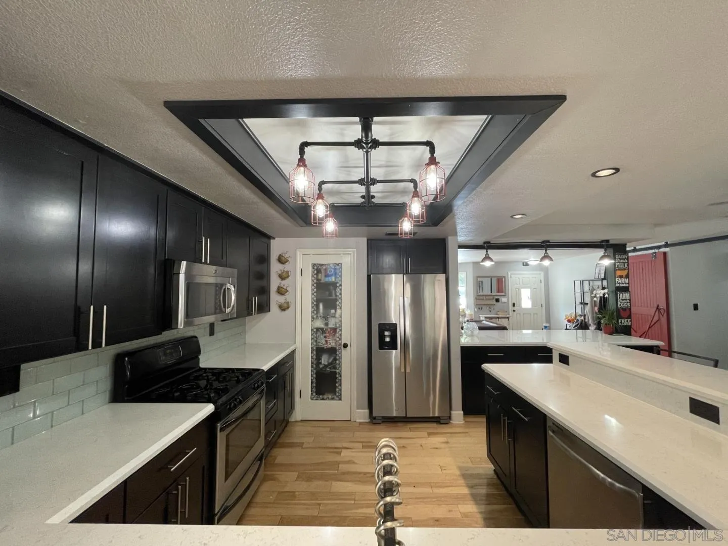 16734 Georgios Way Ramona, CA 92065 - Photo 24 of 35 a large kitchen with a center island and stainless steel appliances