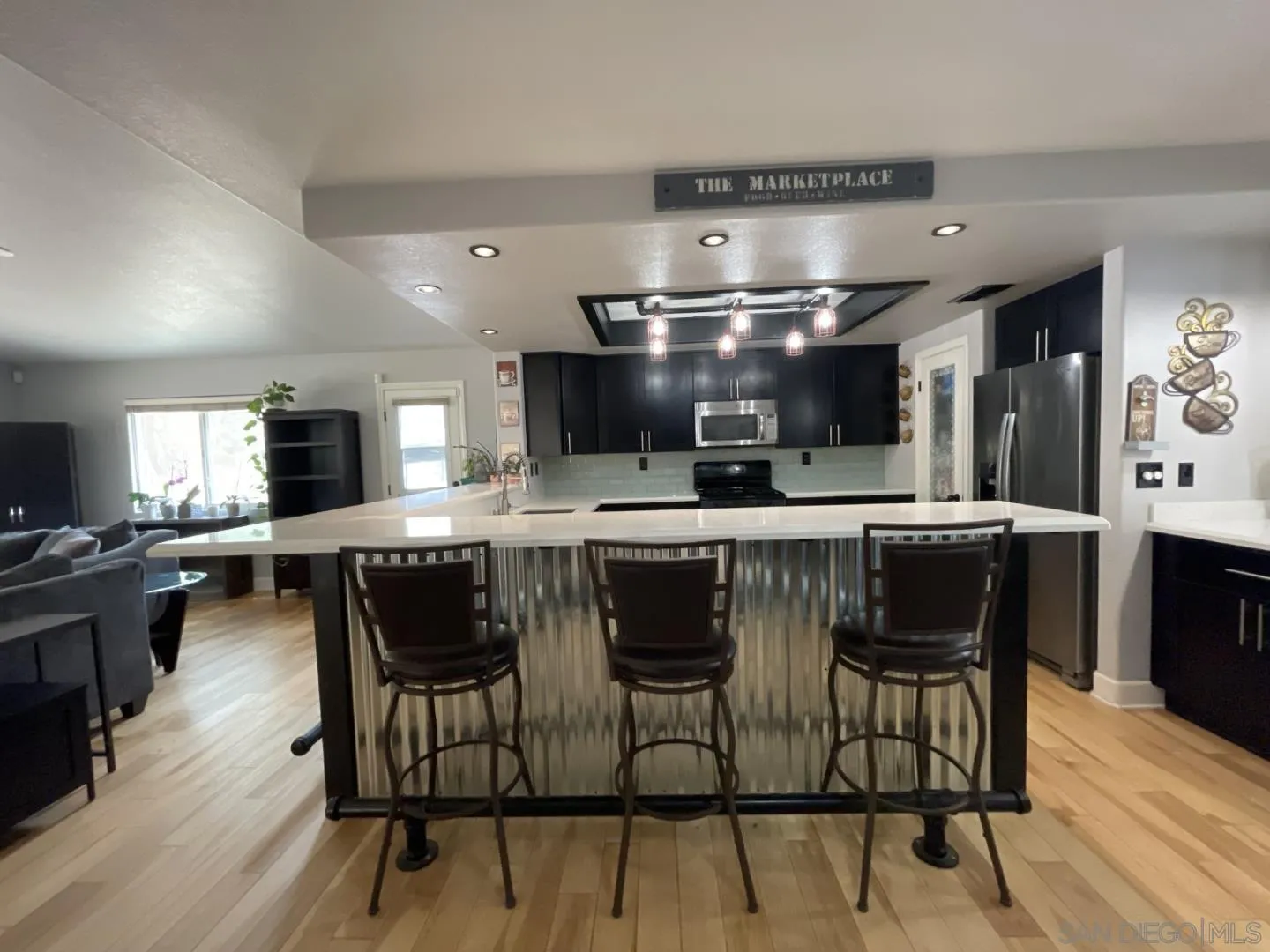 16734 Georgios Way Ramona, CA 92065 - Photo 8 of 35 a kitchen with stainless steel appliances kitchen island granite countertop a table chairs sink and cabinets