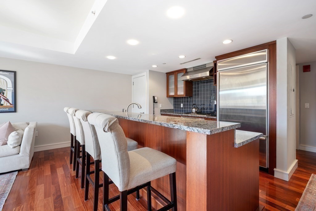 2 Battery Wharf, Unit 2503 Boston, MA 02109 - Photo 8 of 23 a kitchen with kitchen island a appliances dining table and chairs