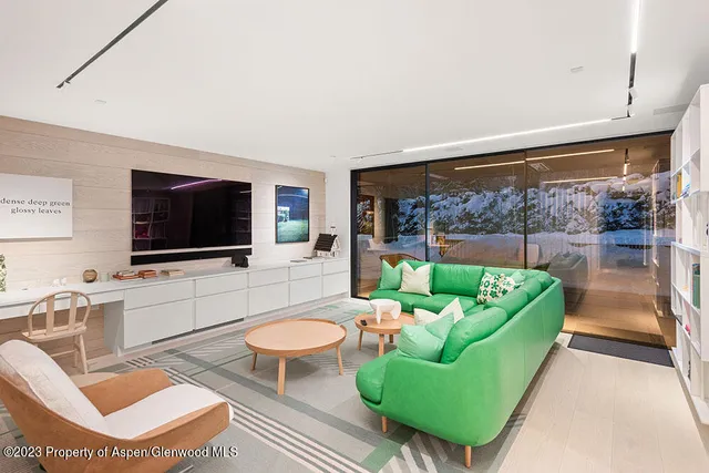 a living room with furniture a flat screen tv and a floor to ceiling window