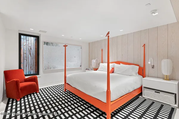 a bedroom with a bed and a dresser with mirror