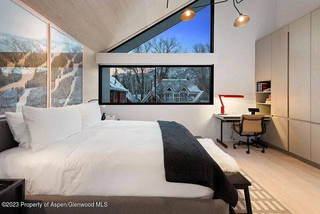 a bedroom with a bed window and a desk