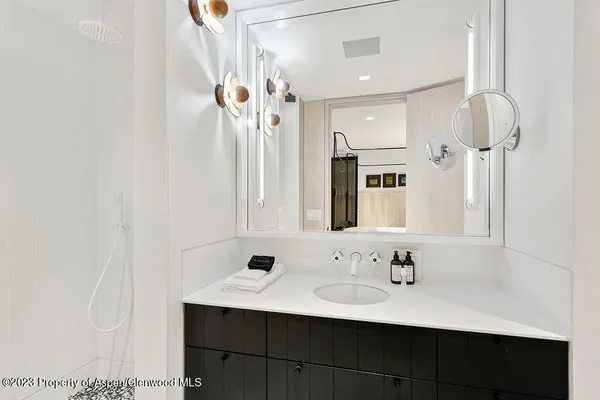 a bathroom with a sink a mirror and shower