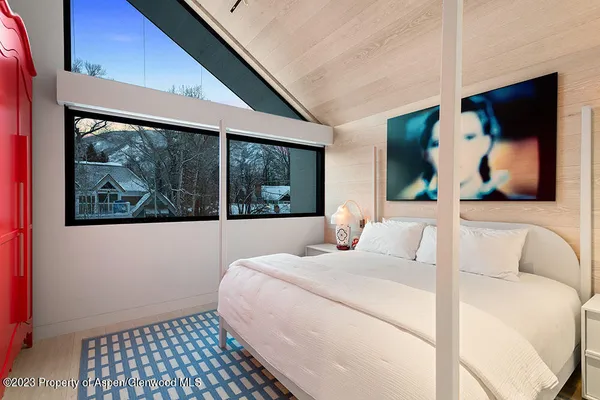 a bedroom with a bed and a painting on the wall