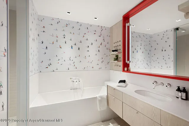 a bathroom with a bathtub sink vanity and mirror