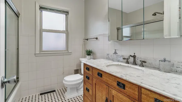 a bathroom with a granite countertop sink a toilet and a mirror