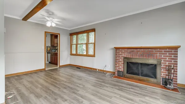 an empty room with windows and fireplace