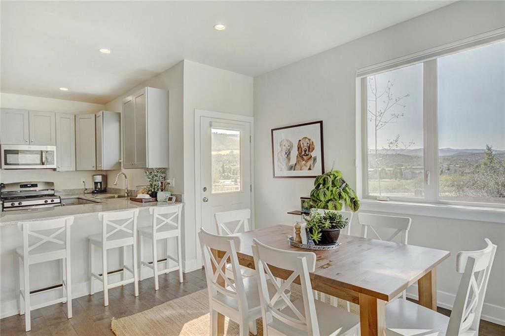 55 Haymaker Street Silverthorne, CO 80498 - Photo 8 of 27 a kitchen with stainless steel appliances granite countertop sink stove and white cabinets with wooden floor