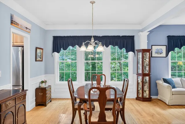 a view of a dining room with furniture a chandelier and window