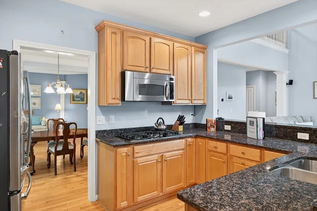 a kitchen with stainless steel appliances granite countertop a stove a sink and a microwave