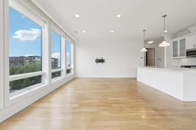 a view of large kitchen with stainless steel appliances kitchen island granite countertop a stove and white cabinets