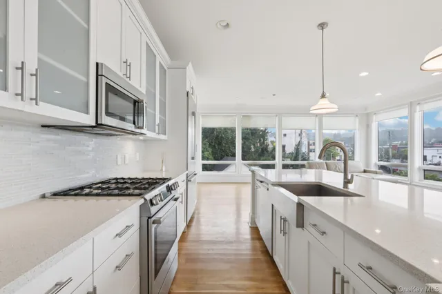 a kitchen with counter top space a sink and appliances