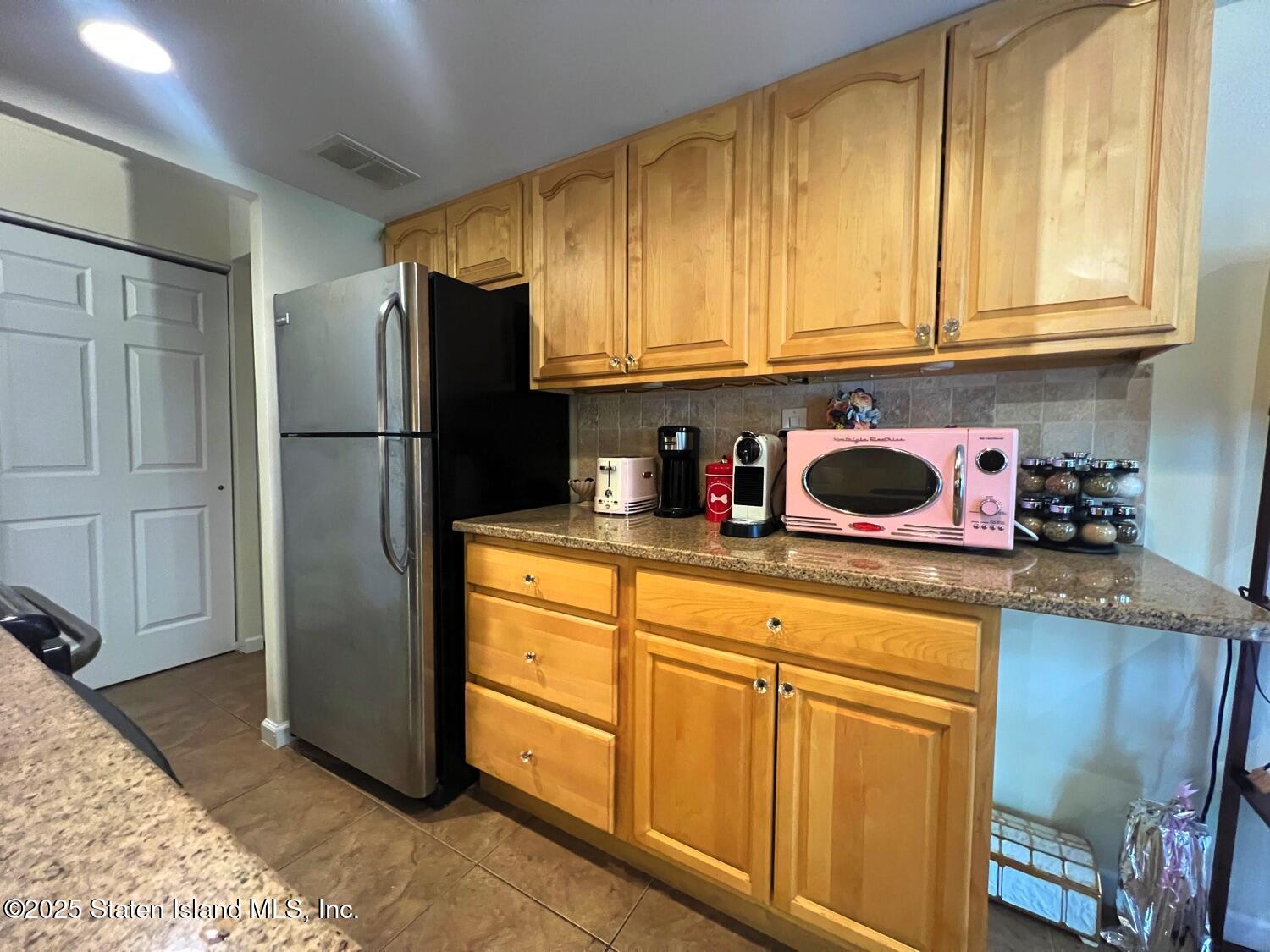11 Windham Loop, Unit 1NN Staten Island, NY 10314 - Photo 11 of 25 a kitchen with stainless steel appliances granite countertop a refrigerator sink and cabinets