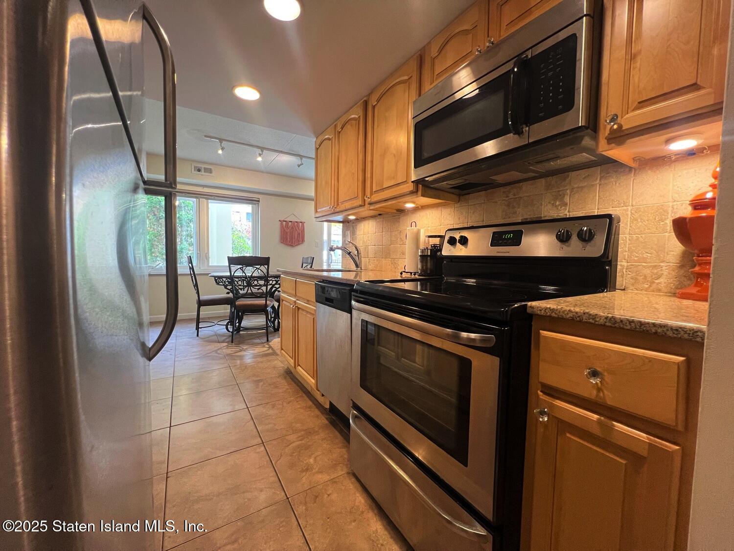 11 Windham Loop, Unit 1NN Staten Island, NY 10314 - Photo 8 of 25 a kitchen with stainless steel appliances granite countertop a stove a sink and a microwave
