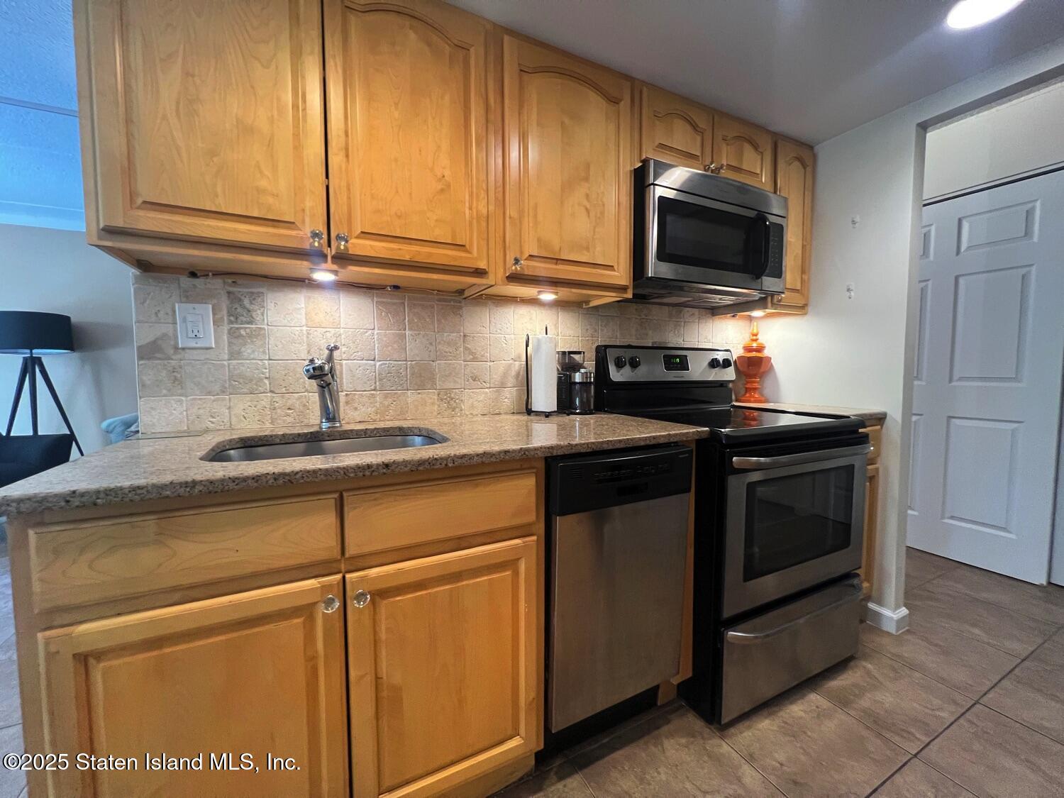 11 Windham Loop, Unit 1NN Staten Island, NY 10314 - Photo 9 of 25 a kitchen with stainless steel appliances granite countertop a sink and a microwave