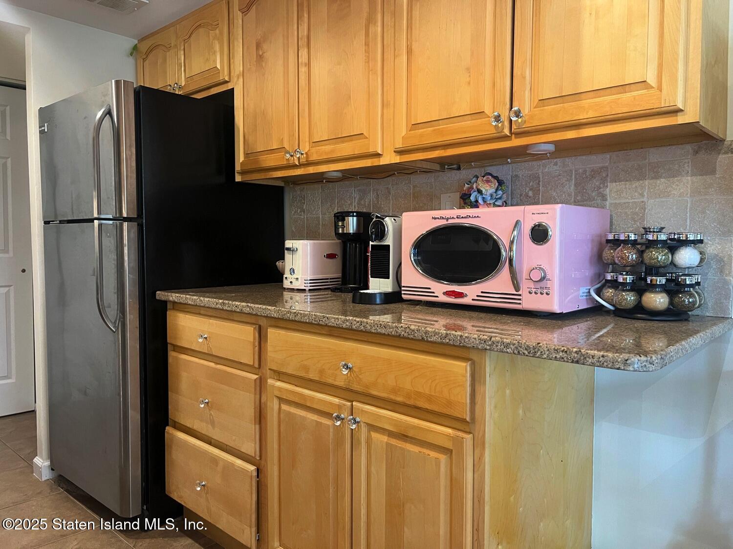 11 Windham Loop, Unit 1NN Staten Island, NY 10314 - Photo 10 of 25 a kitchen with granite countertop cabinets and refrigerator