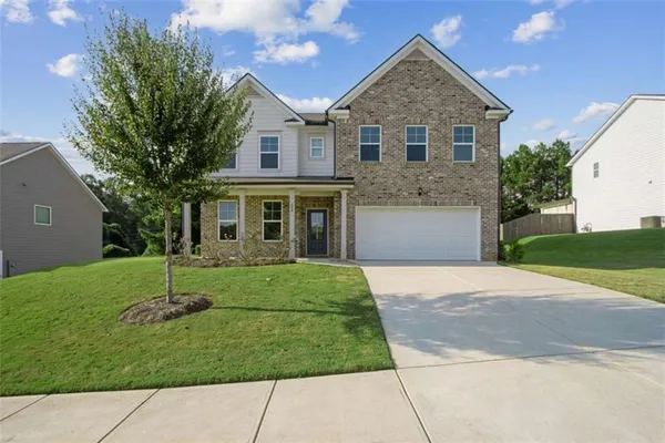 a front view of a house with a yard and garage