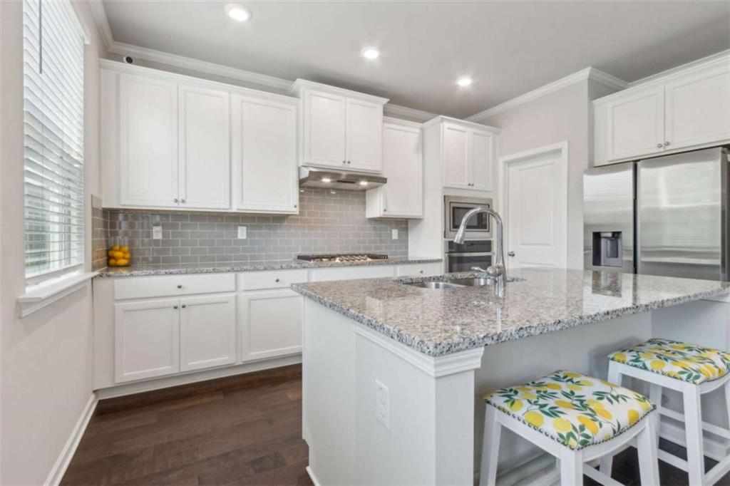 429 Paxton Lane Jefferson, GA 30549 - Photo 22 of 53 a kitchen with stainless steel appliances granite countertop a sink a stove a microwave a dining table and chairs